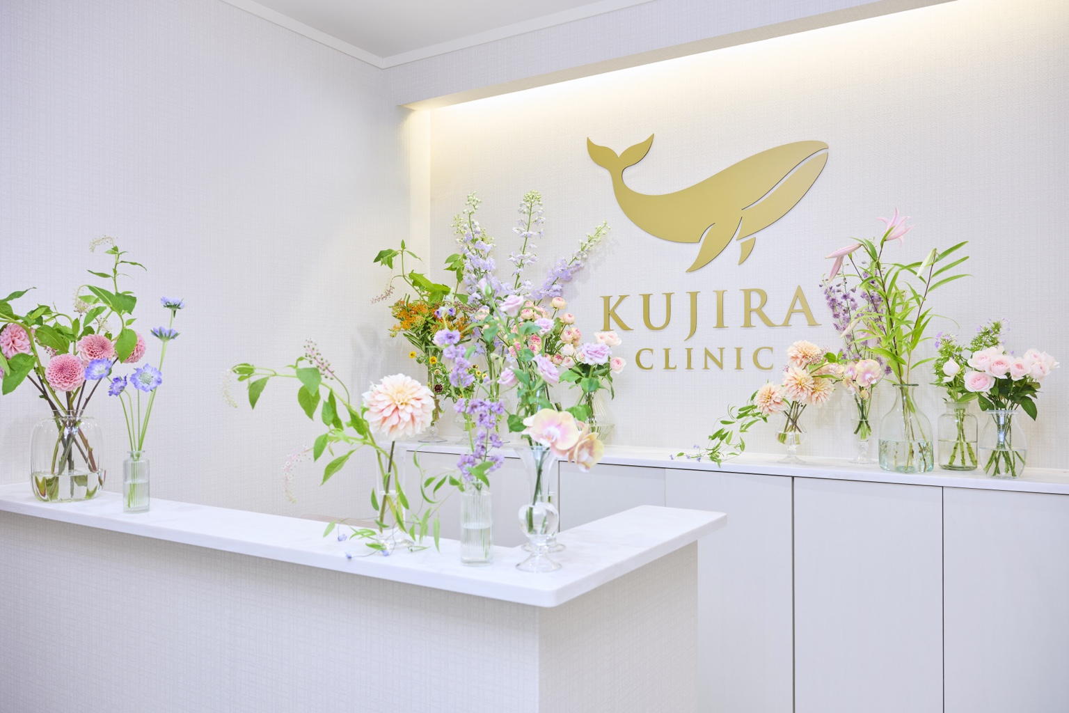 季節の花とKUJIRA CLINICのロゴが迎える受付